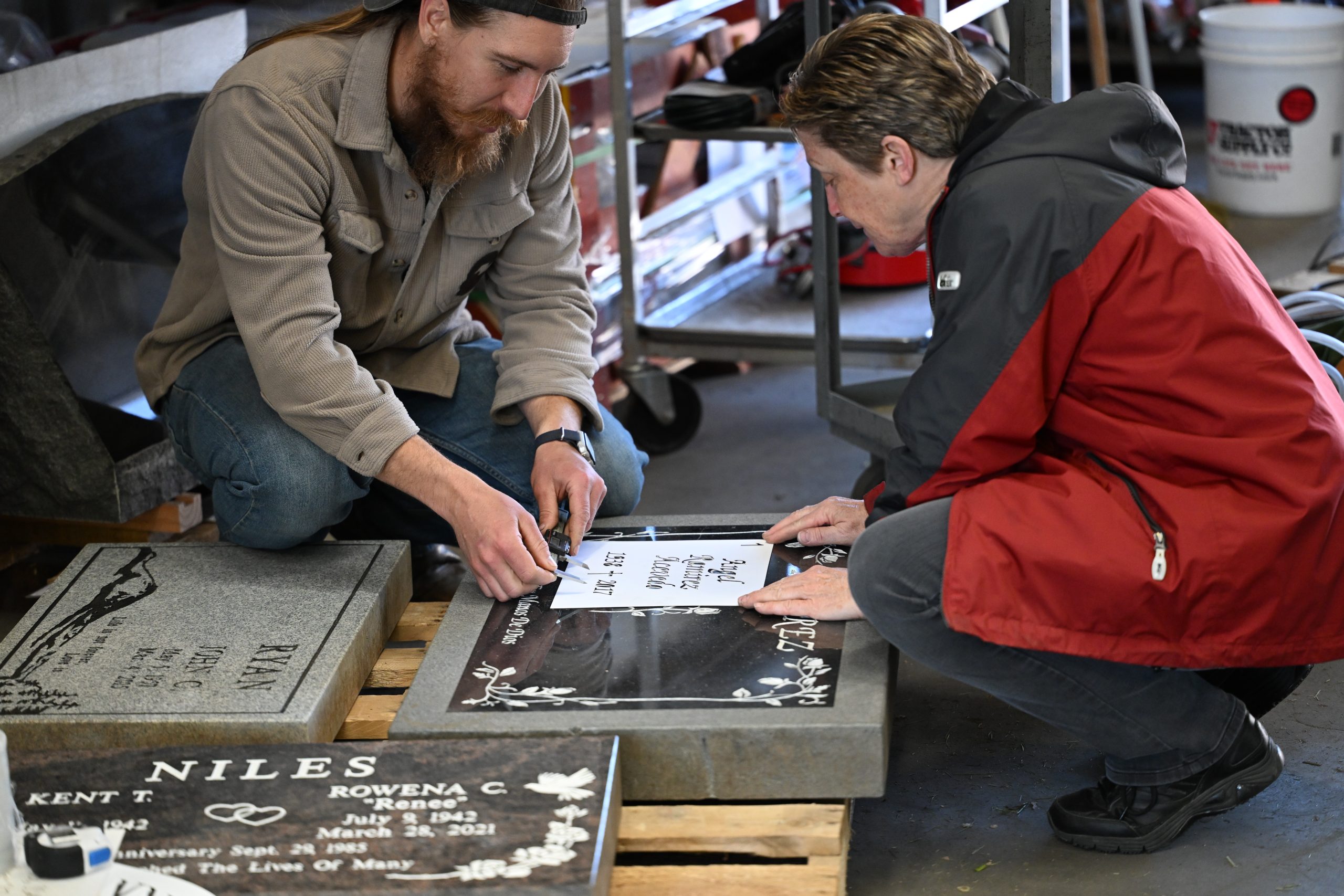 Two people design a gravestone together.