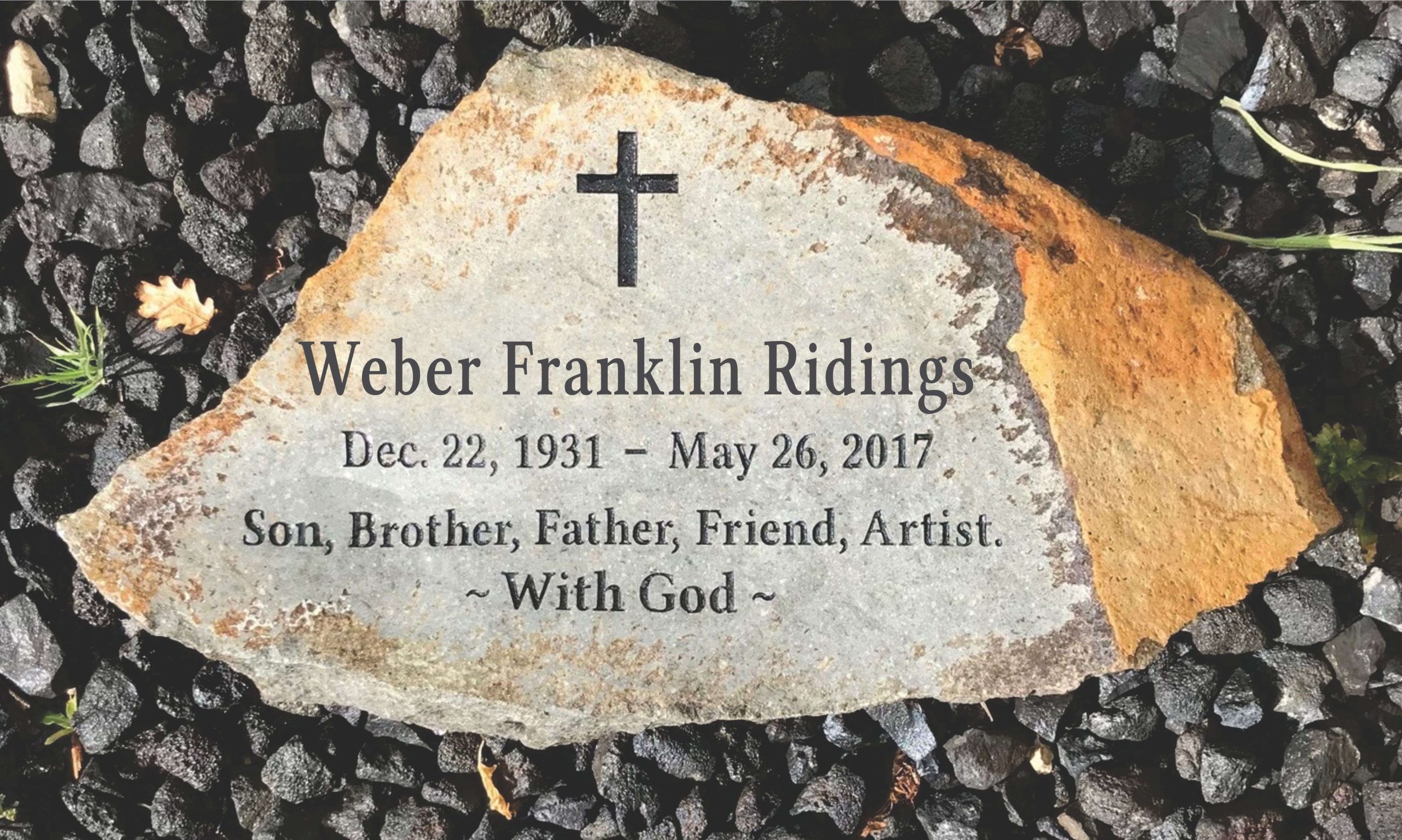 Memorial stone with cross and personal details.