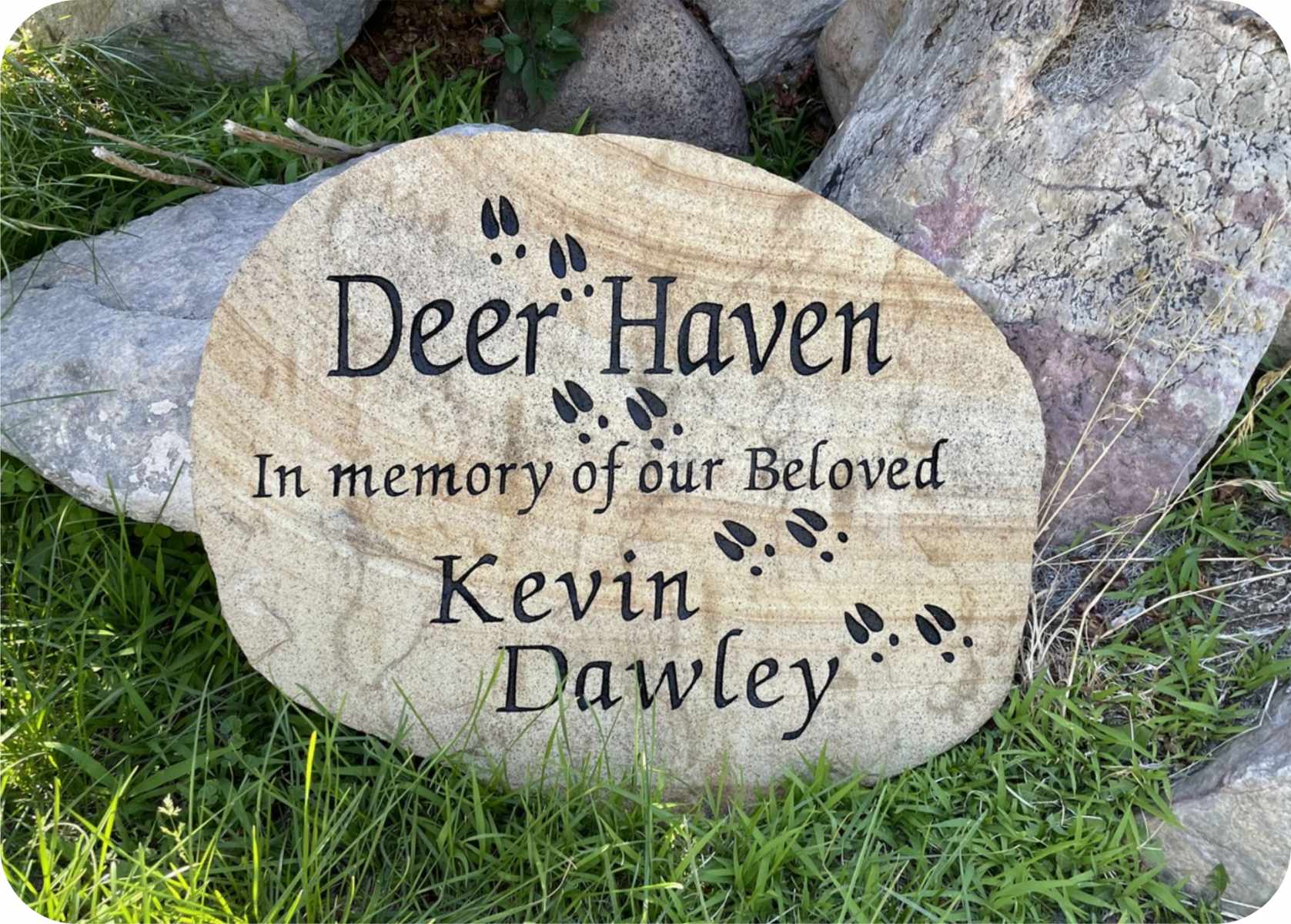 Memorial stone with deer footprints and carved text.