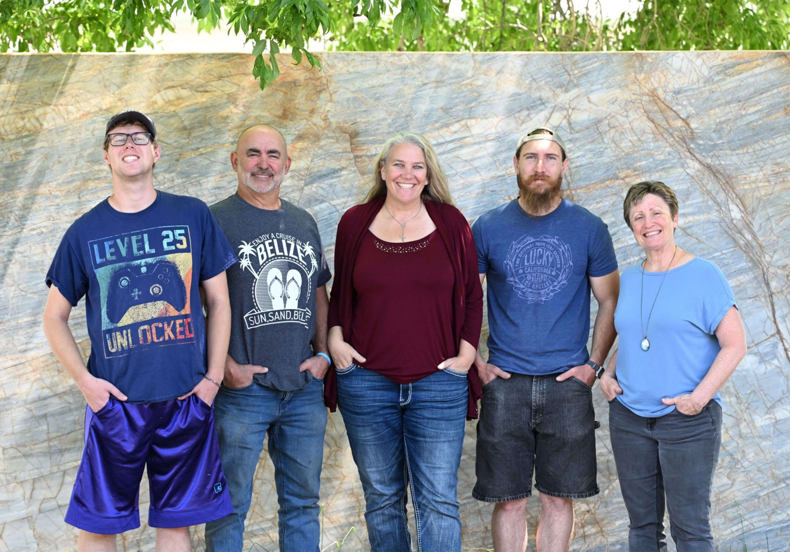 Group of five people smiling outdoors.