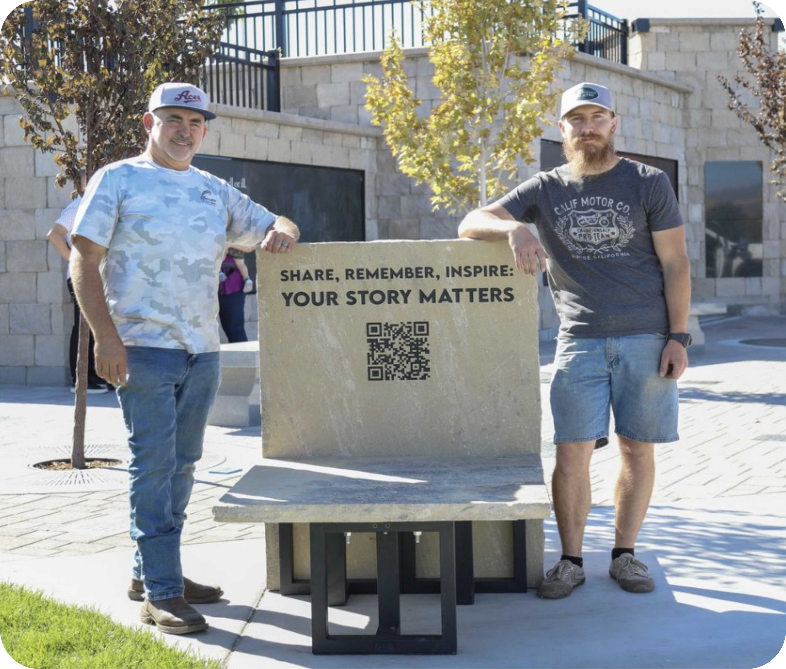 Two men beside inspirational bench with QR code.